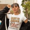 Woman wearing a white t-shirt with a cartoon character and the text "Born to Debate, Forced to attend school"